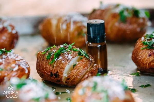 A close up view of hasselback potatoes drizzled with herb butter and topped with fresh parsley and parmesan cheese on a baking pan.