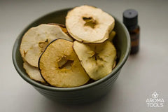 A bowl filled with dehydrated apple slices flavored with cinnamon essential oil.
