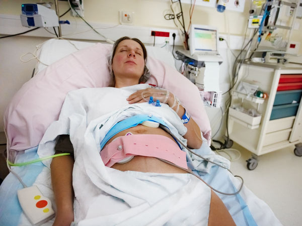 pregnant woman laying in a hospital bed with monitoring machines