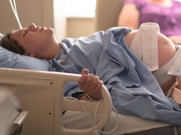 woman laying in a hospital bed, in labour