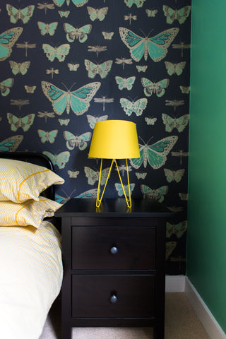 bedroom with butterfly wallpaper yellow lamp arsenic walls