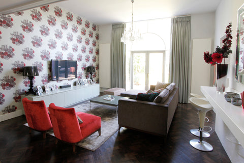 Living room design with feature wall of cole and son wallpaper, romo velvets, the sofa and chair furniture in reds and teals