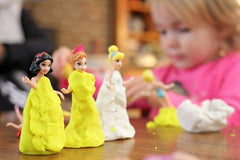 Young child playing with dough and dolls