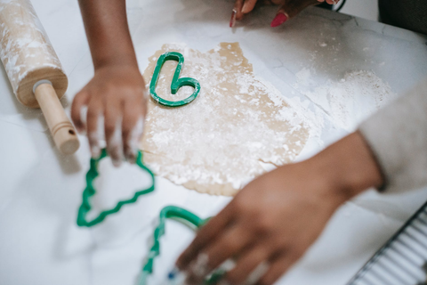 Kids pressing holiday cookie cutters onto dough