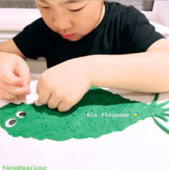 little boy making flounder out of dough