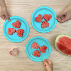 watermelon cut into heart shapes on blue plates