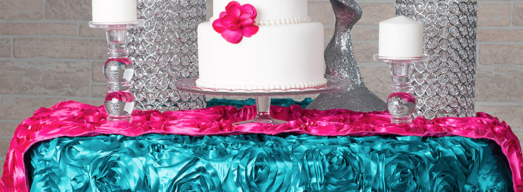 easy event fabrics in turquoise and fuchsia satin rosette tablecloths and table runners on a cake table