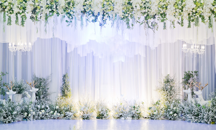 All-white wedding backdrop with floral decor