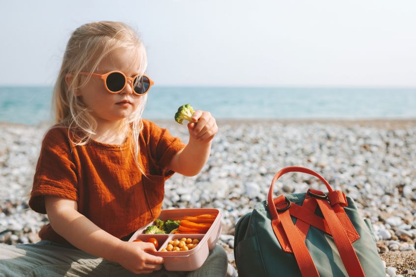 girl eating by the beach