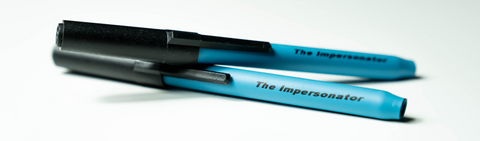 Studio product shot of two of SLEEK USA's "The Impersonator" one-hitter, concealable smoking pens without product packaging