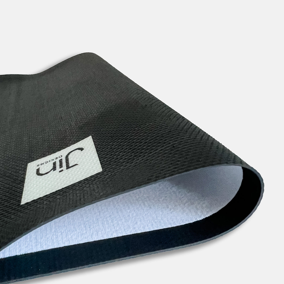 Anti-slip rubber backing on desk mat and Jin Designs logo