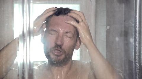 Man in shower before applying cologne