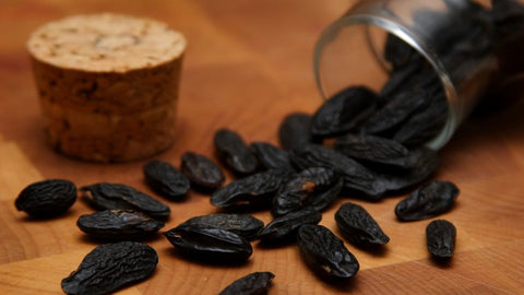 Tonka Beans pouring onto wooden counter