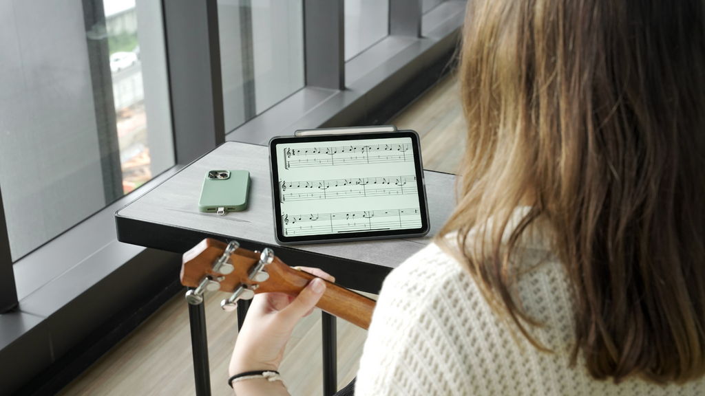 Chica tocando guitarra utilizando su iPad