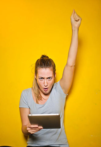 Girl Celebrating against a yellow background.