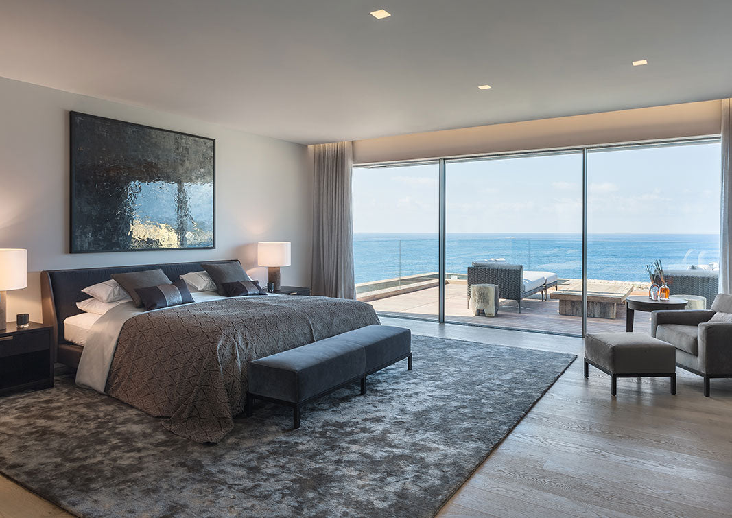 Elegantes graues Schlafzimmer mit Balkon und Meerblick