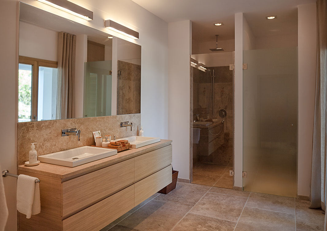 Badezimmer mit Holzschubladen und Steinboden