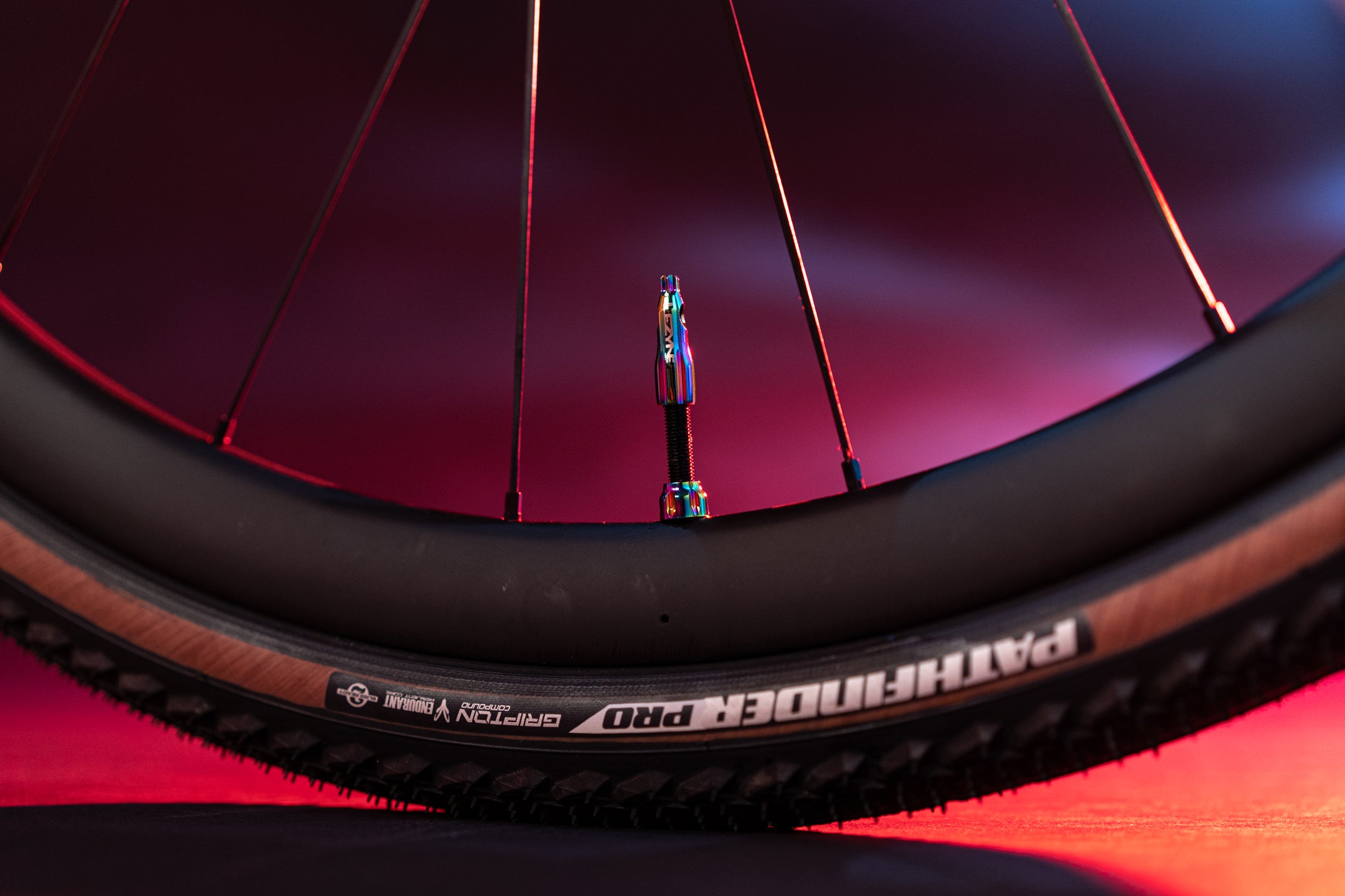 A tire valve mounted to a bicycle tier with the word Lezyne printed on it.