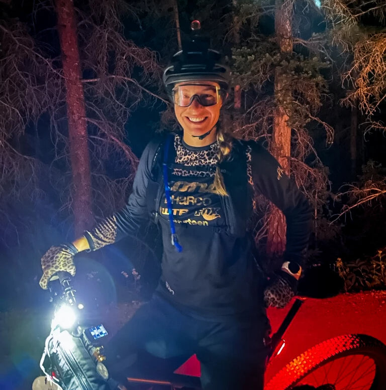 Becky posing with her bike at night