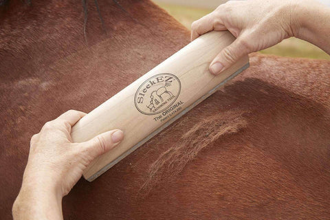 The 10-inch SleekEZ grooming blade being used on the back of a chestnut horse.