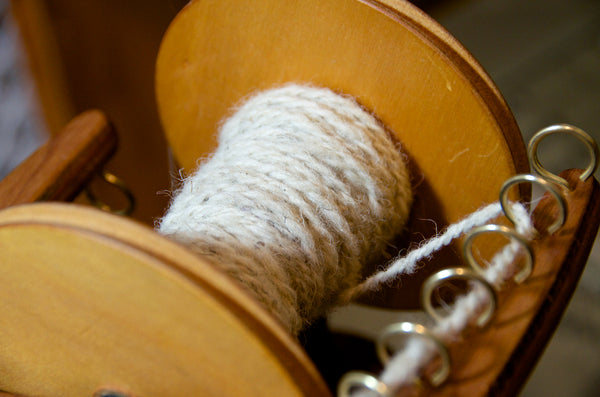 Plied yarn on spinning wheel bobbin