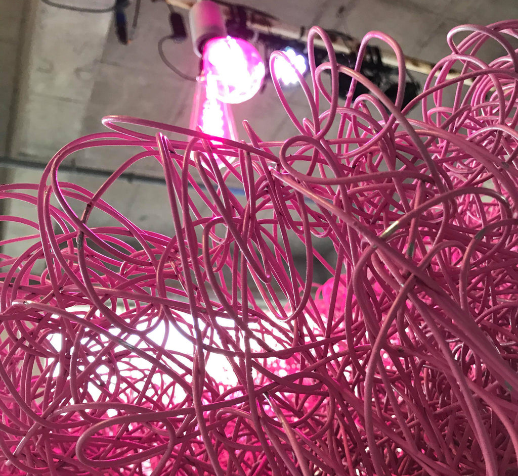 pink sculpture made of tangled thick wire