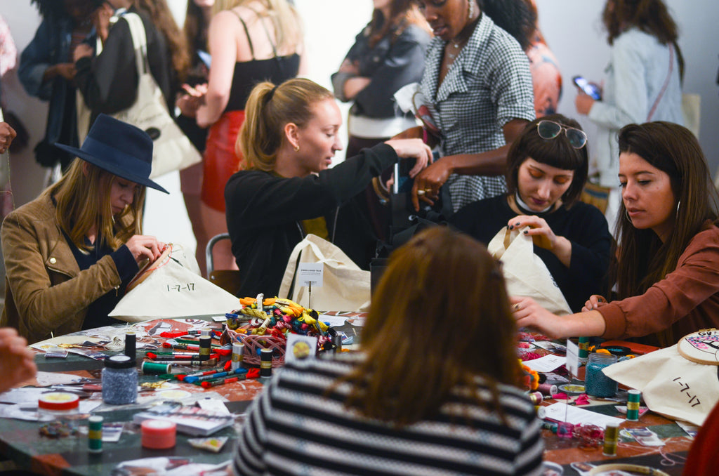 embroidery workshop with several people sitting around a table with embroidery materials in front of them