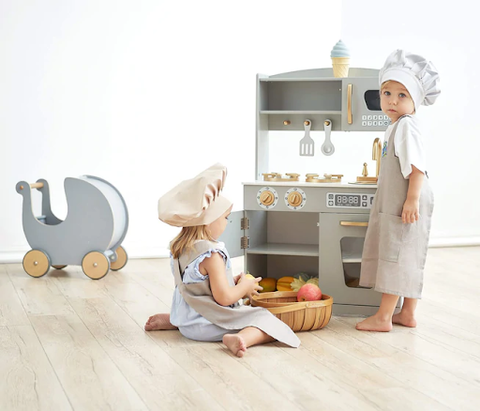 toddler boy and toddler girl playing with kitchen play set