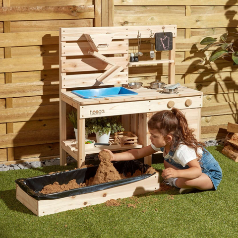 Child playing outdoors with Mud Kitchen