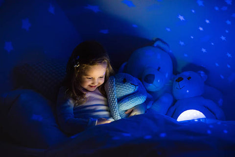 Girl sitting in room with blue nightlight