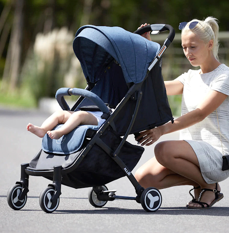 Mum kneeling behind pushchair and lowering back of pushchair to lie-flat position