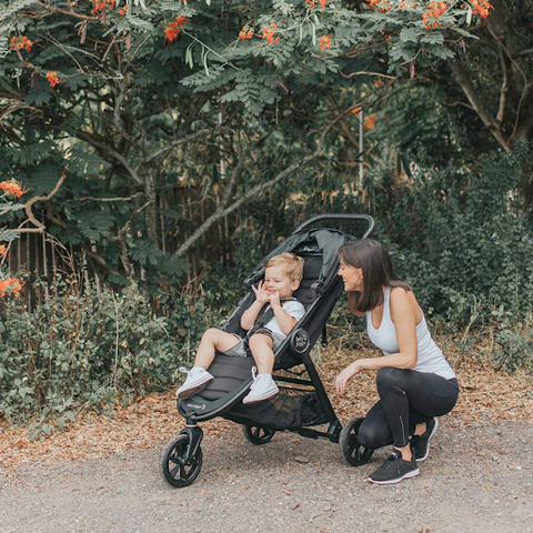 Mum kneeling next to toddler in stroller