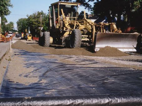 Geotex woven fabric being installed on road