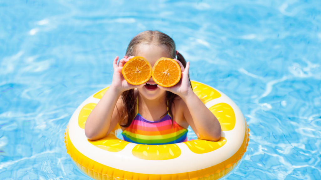 Girl in pool with oranges