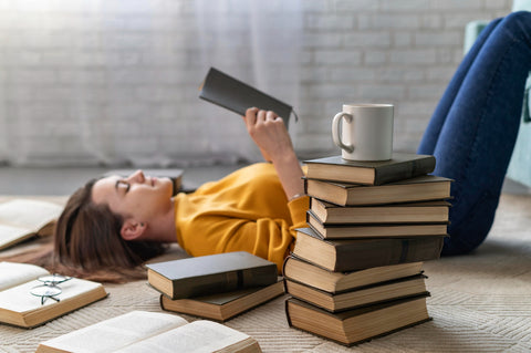 young woman reading in piles of books