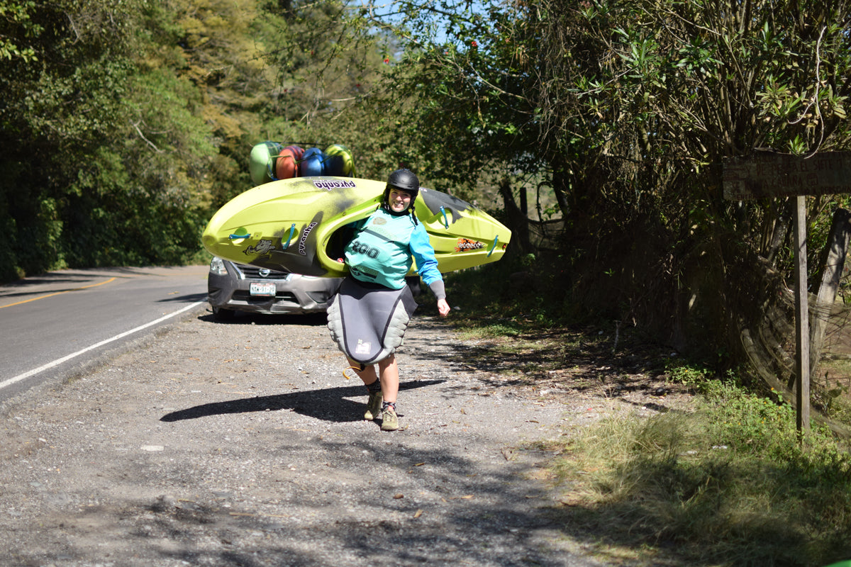 Kayaker, Sofia Reinoso, walking with her kayak on her shoulder.