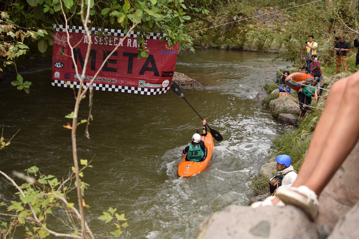 Whitewater kayaker crossing the finish line at a kayak race.