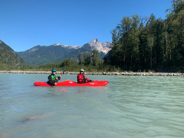 Two people in a tandem duo whitewater kayak