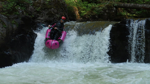 Packrafter packrafting over a small waterfall on the Salmon River Gorge in Oregon.