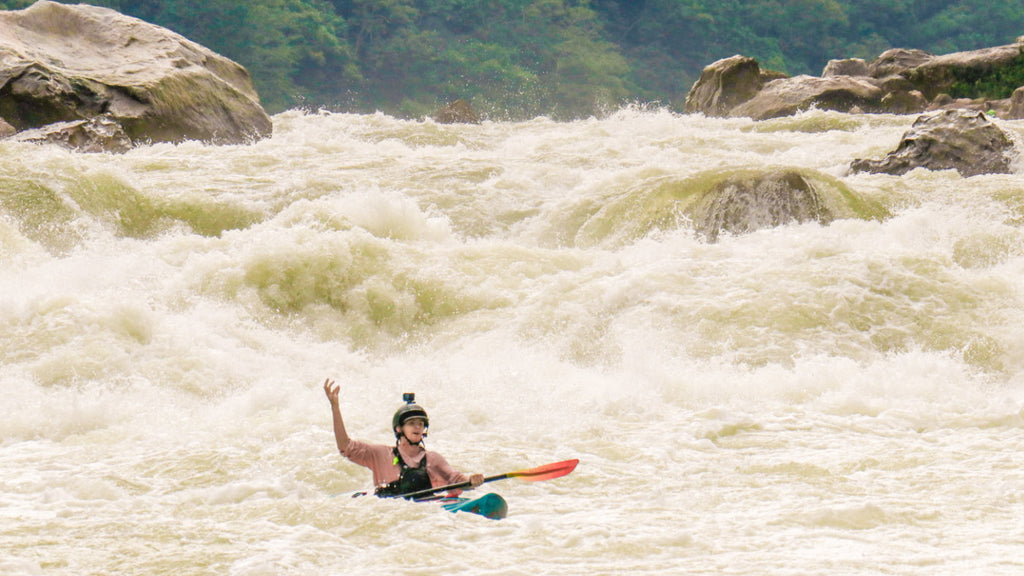 Kayaker celebrating at the bottom of a rapid