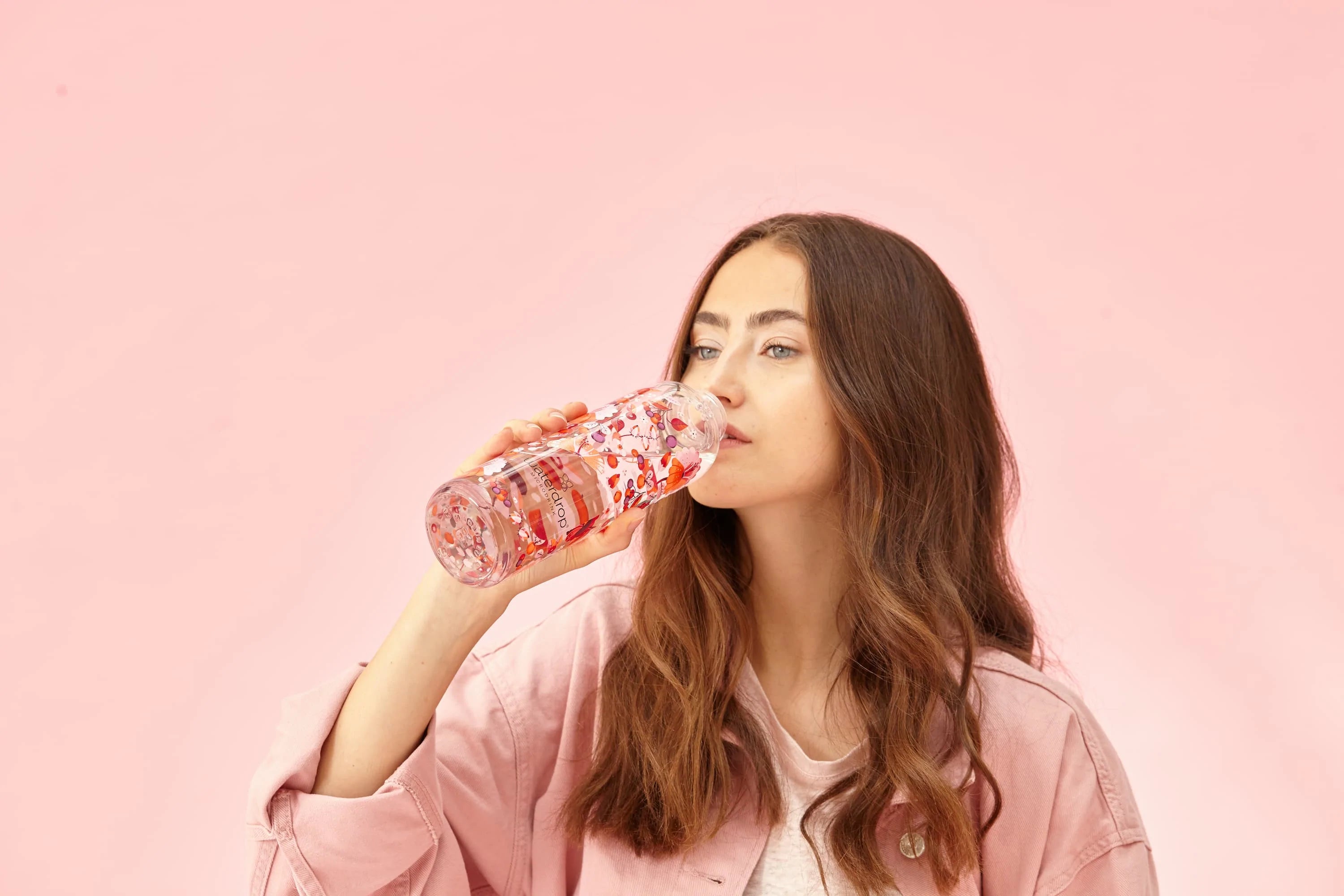 Woman drinks water out of a waterdrop® Edition Glass Bottle