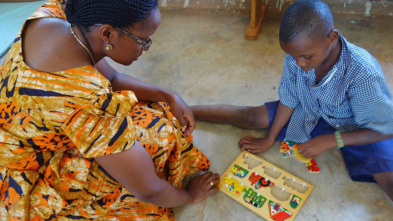 A child playing a board game with a volunteer