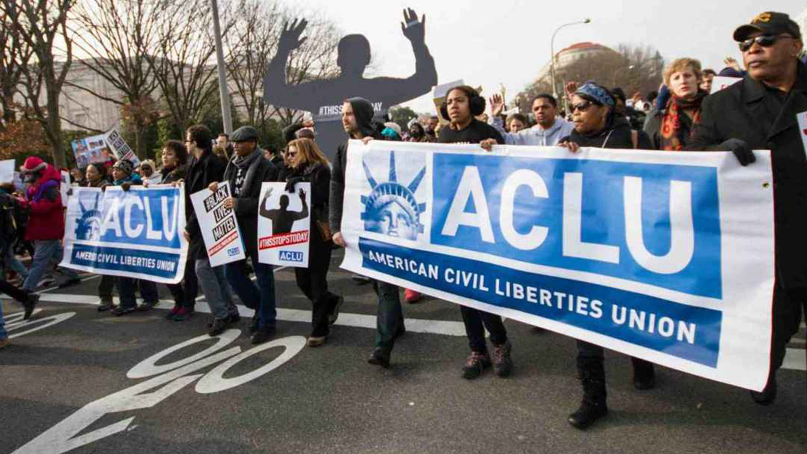 People marching with an ACLU banner.