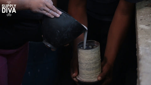 Plaster being poured into a flask