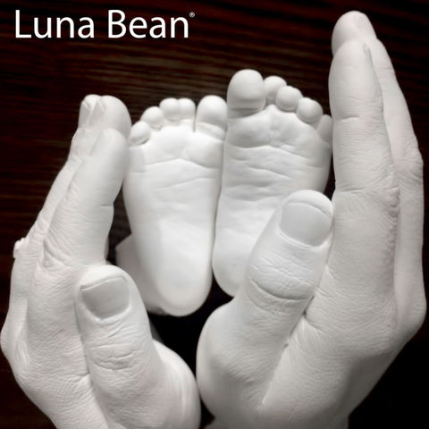 sculpture of baby feet and parent hands