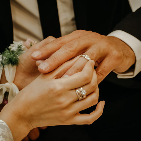 Wedding band being place on mans hand