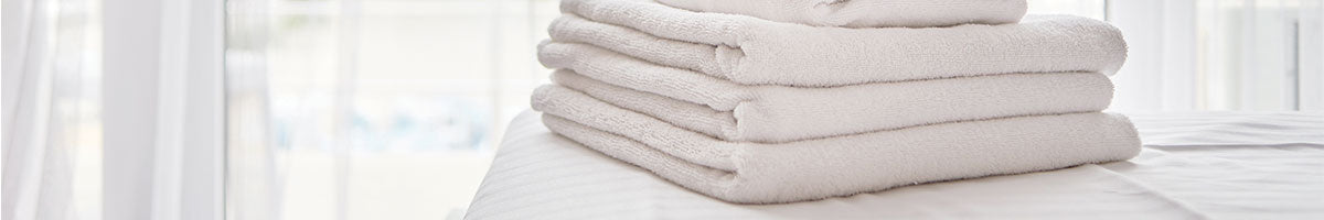 folded white towels on a white counter