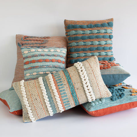 Stack of handwoven cushions in a modern rustic style with colour and texture