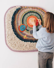 Irregular shaped frame loom with woven artwork by Tammy Kanat