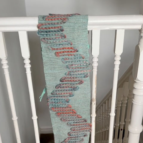 Handwoven fabric drying over a bannister to avoid distortion